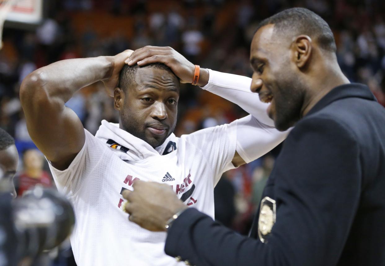 Dwyane Wade listens to LeBron James and tries to keep it together. (AP)