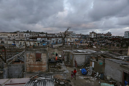 People walk past debris after a tornado ripped through a neighbourhood in Havana, Cuba January 28, 2019. REUTERS/Fernando Medina