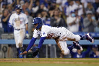 Los Angeles Dodgers' Mookie Betts slides into home plate to score on a double by Corey Seager during the eighth inning of the team's baseball game against the Atlanta Braves on Tuesday, Aug. 31, 2021, in Los Angeles. (AP Photo/Marcio Jose Sanchez)