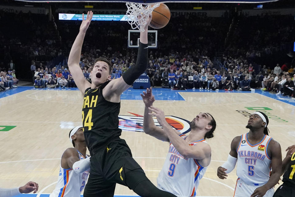 Utah Jazz center Walker Kessler (24) dunks in front of Oklahoma City Thunder guard Shai Gilgeous-Alexander, left, forward Dario Saric (9) and guard Luguentz Dort (5) in the first half of an NBA basketball game Sunday, March 5, 2023, in Oklahoma City. (AP Photo/Sue Ogrocki)