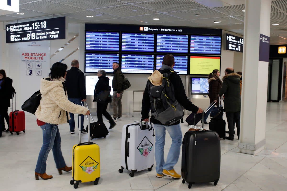 Passengers check the information board at the Paris-Orly airport (AP)