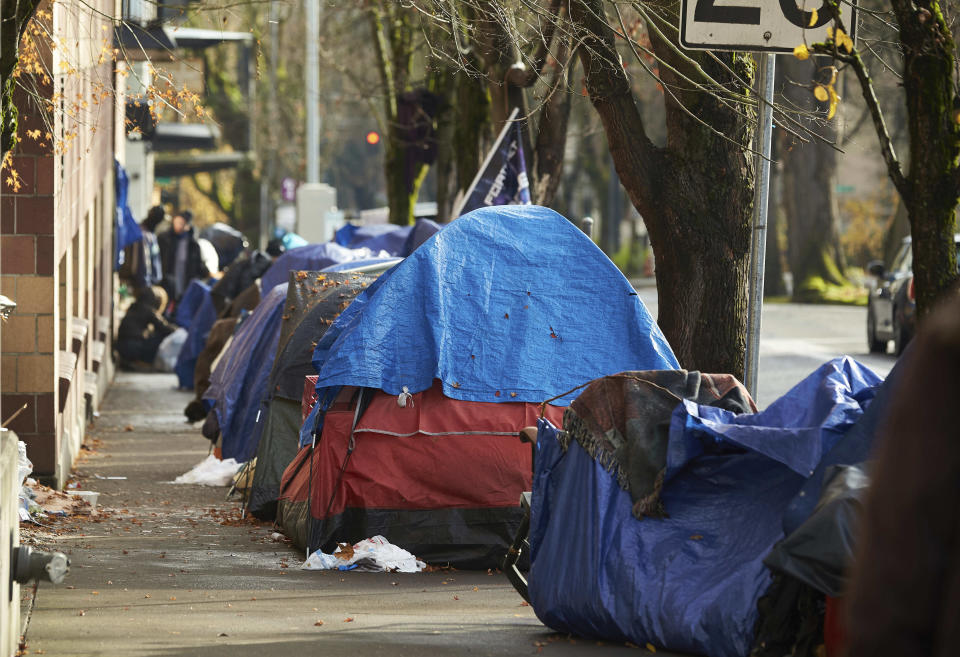 FILE - Tents line the sidewalk on Clay Street, Dec. 9, 2020, in Portland, Ore. Momentum is building in a case regarding homeless encampments before the U.S. Supreme Court that could have major implications for cities as homelessness nationwide has reached record highs. (AP Photo/Craig Mitchelldyer, File)