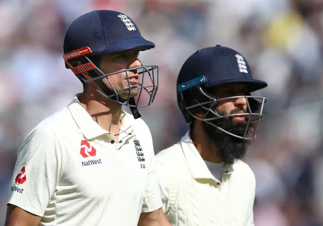 Sir Alastair Cook (left) and Moeen Ali leave the field