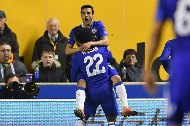 Chelsea's Spanish midfielder Pedro (top) celebrates with teammate Willian after scoring the opening goal of their English FA Cup fifth round match against Wolverhampton Wanderers on February 18, 2017