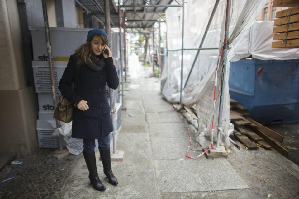 Ruth Stirati, a Rome native, who helps Italian investors find property real estate in the German capital phones prior to an inspection in an empty apartment with an Italian family at the district Prenzlauer Berg in Berlin, Thursday, Nov. 1, 2012. Buying a home in Berlin is widely viewed as one of the safest investments a German, or any European, can make. That is why some real-estate experts are worried the market could get overheated. (AP Photo/Markus Schreiber)