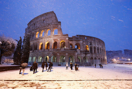 The ancient Colosseum is seen during a heavy snowfall early in the morning in Rome. REUTERS/Remo Casilli