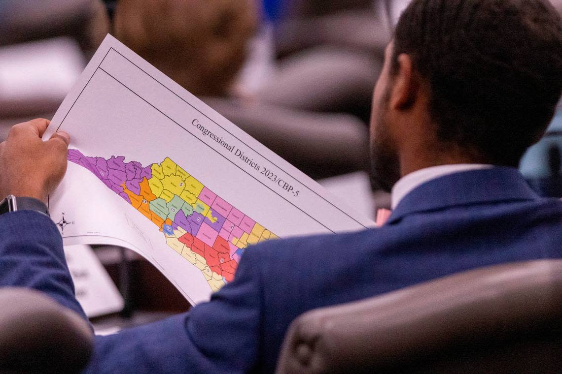A North Carolina Senate staffer looks over a proposed congressional map during a Senate Committee on Redistricting and Elections meeting at the Legislative Office Building in Raleigh, Thursday, October. 19, 2023.