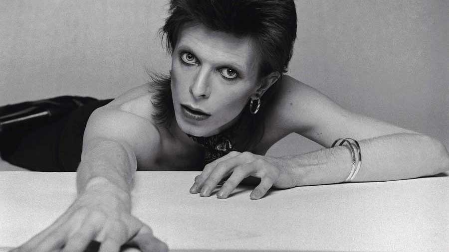  David Bowie on a bed, leaning towards the camera, photographed for the Diamond Dog album cover, circa 1974 . 