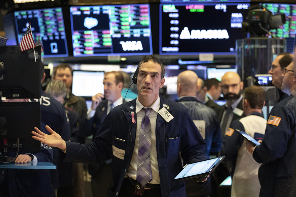 FILE - In this Wednesday, Feb. 26, 2020, file photo, stock trader Gregory Rowe works at the New York Stock Exchange. The S&P 500 has lost more than 10% from its record high as worries have built that a fast-spreading new virus will slam economies and corporate profits around the world. That means stocks just went through a “correction” in the stilted parlance of market watchers. (AP Photo/Mark Lennihan, File)