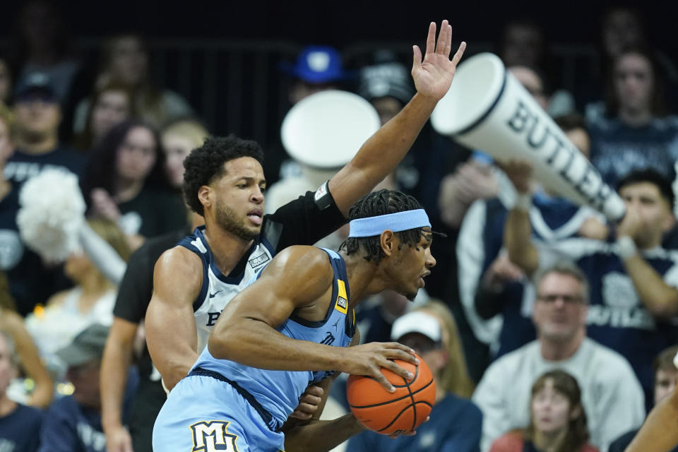 Marquette's Justin Lewis, right, goes to the basket against Butler's Bryce Nze (10) during the first half of an NCAA college basketball game, Saturday, Feb. 12, 2022, in Indianapolis. (AP Photo/Darron Cummings)