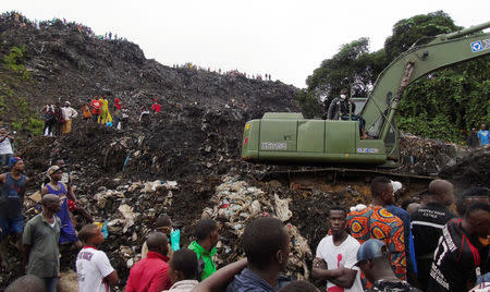 An excavator operates at the site of a mudslide at a rubbish landfill in the Dar Es Salam neighbourhood, on the outskirts of the capital Conakry, Guinea August 22, 2017. REUTERS/Saliou Samb