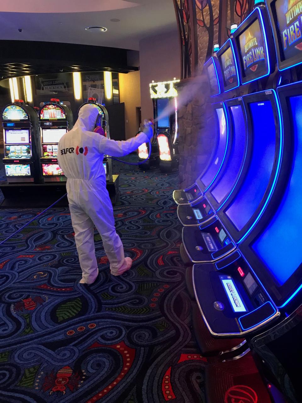 A worker for Belfor Property Restoration in Birmingham, Michigan, sprays disinfectant while deep cleaning a casino to remove any trace of the coronavirus.