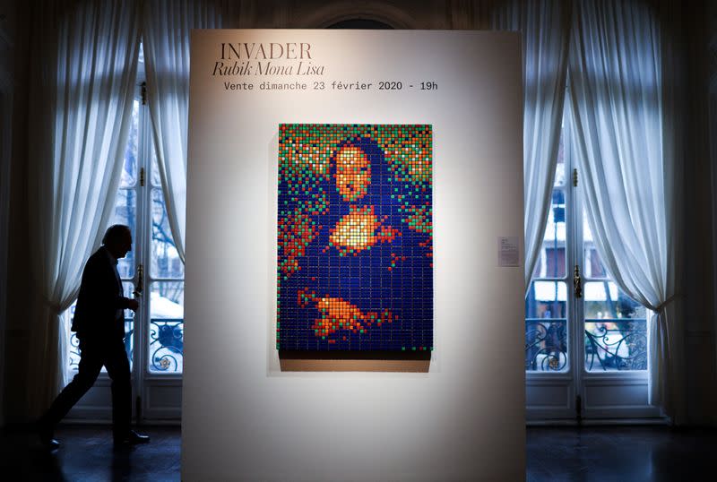 A man walks by the Rubik Mona Lisa (2005) by French street artist Invader displayed at ArtCurial in Paris