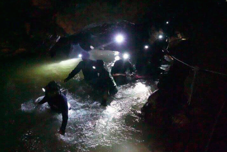 Rescue teams walk inside the cave complex where 12 boys and their football coach went missing (Picture: PA)