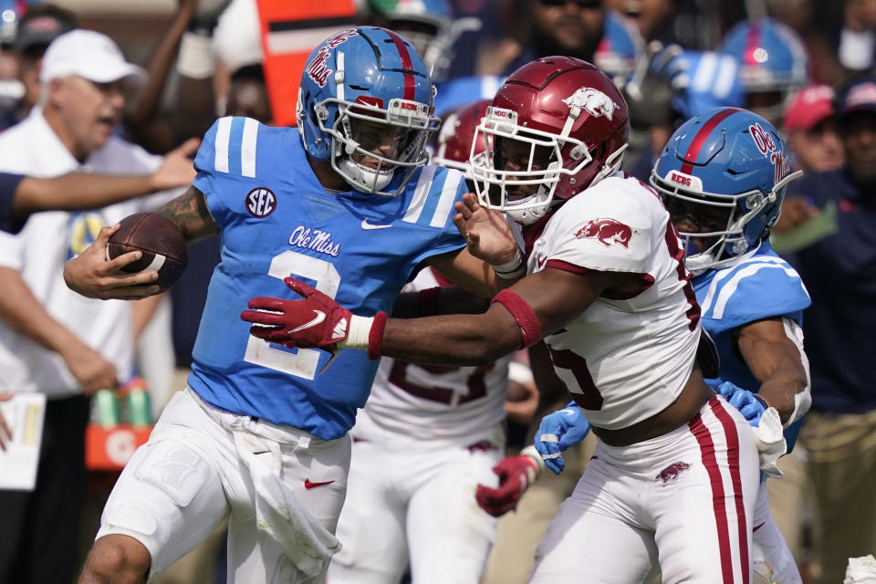 Mississippi quarterback Matt Corral, left, pushes off an Arkansas defender during the second half of an NCAA college football game, Saturday, Oct. 9, 2021, in Oxford, Miss. Mississippi won 52-51.(AP Photo/Rogelio V. Solis)