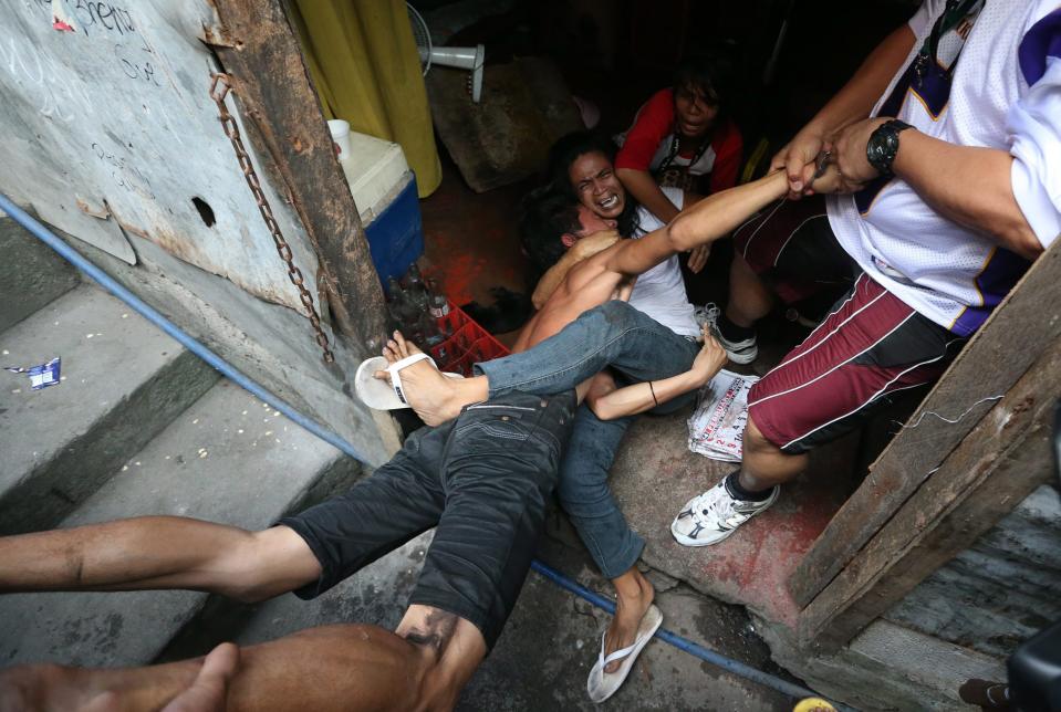 epa04044203 Filipino informal settlers Penny Mercado (2-R) hugs her husband Brix, 27, (L) while being arrested by plainclothes policemen inside their house during a demolition of shanties at Sitio San Roque in Quezon City, east of Manila, Philippines, 27 January 2014. Throwing rocks, pillboxes, and even human waste, illegal settlers barricaded the demolition team in Baranggay Bagong Pag-asa. Four residents were arrested and twelve were reported injured. Residents report receiving cash from 300 to 450 US dollar in exchange for their voluntary relocation. Earlier, hundreds of the urban poor marched to the city hall in protest of the demolition that will pave the way for the rise of a business district. EPA/DENNIS M. SABANGAN