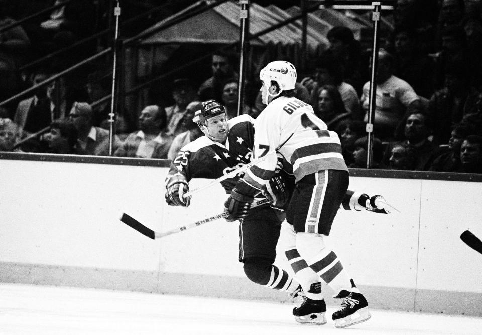 FILE - Washington Capitals center Doug Jarvis, left, is knocked off his skates as he collides with New York Islanders Greg Gilbert in Uniondale, N.Y., Dec. 23, 1983. Philadelphia Flyers defenseman Keith Yandle tied Jarvis for the NHL record of 964 consecutive games played against Dallas on Monday, Jan. 24, 2022. (AP Photo/Richard Drew, File)