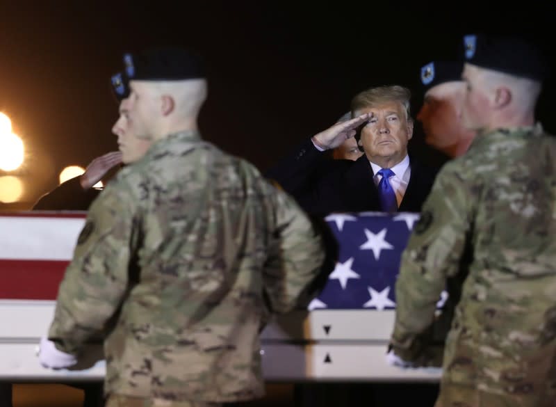 U.S. President Donald Trump salutes during a dignified transfer at Dover Air Force Base