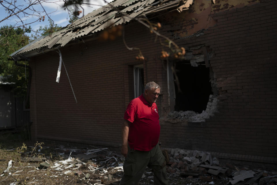 The head of the rapid response unit Taras Logginov walks in front of the damaged building of the Ukrainian Red Cross Society that was hit last week during a Russian attack in Sloviansk, Ukraine, Monday, Sept. 5, 2022. (AP Photo/Leo Correa)