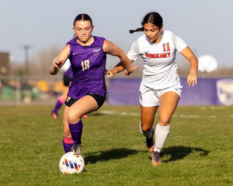 Fowlerville's Autumn Carr (18) plays the ball in front of Pinckney's Julia Garcia Monday, April 8, 2024.