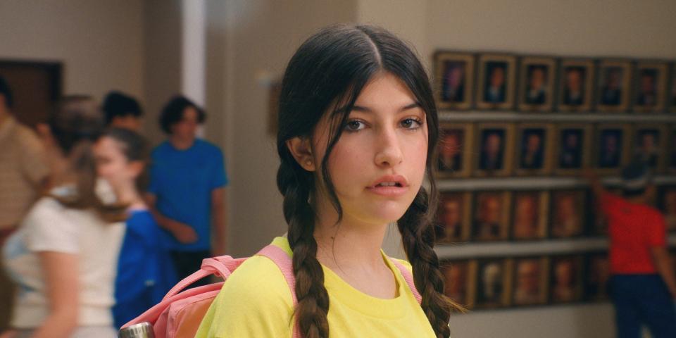 Sunny Sandler with braided pigtails in a yellow shirt in school in "You Are So Not Invited to My Bat Mitzvah."