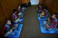 Afghan music students play the Robab during class at the Afghanistan National Institute of Music in Kabul