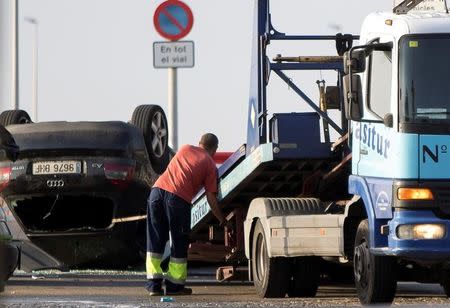 A worker loads a car on a tow truck where the police investigate the scene of an attack in Cambrils, south of Barcelona, Spain, August 18, 2017. REUTERS/Stringer