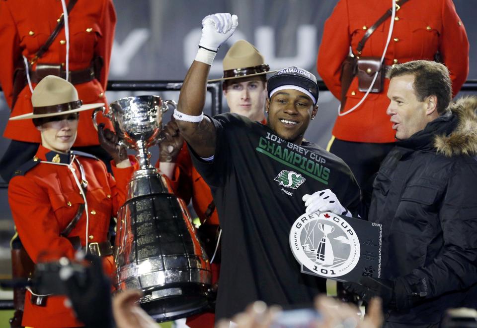 The Saskatchewan Roughriders Kory Sheets accepts the MVP trophy from CFL Comissioner Mark Cohon (R) after the Roughriders defeated the Hamilton Tiger-Cats in the CFL's 101st Grey Cup championship football game in Regina, Saskatchewan November 24, 2013. REUTERS/Mark Blinch (CANADA - Tags: SPORT FOOTBALL)