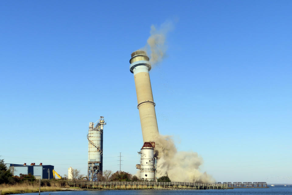 The smokestack at the former B.L. England power plant in Upper Township, N.J., is toppled during a control demolition, Thursday, Oct. 26, 2023. The site will be redeveloped as a mixed use residential and commercial project, and a nearby electrical substation will be used to connect New Jersey's soon-to-come offshore wind farms with the electrical grid. (AP Photo/Wayne Parry)