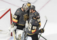 Vegas Golden Knights goalie Robin Lehner (90) and teammates Nate Schmidt (88) and Alex Tuch (89) celebrate the team's 3-0 win over the Dallas Stars in Game 2 of the NHL hockey Western Conference final, Tuesday, Sept. 8, 2020, in Edmonton, Alberta. (Jason Franson/The Canadian Press via AP)