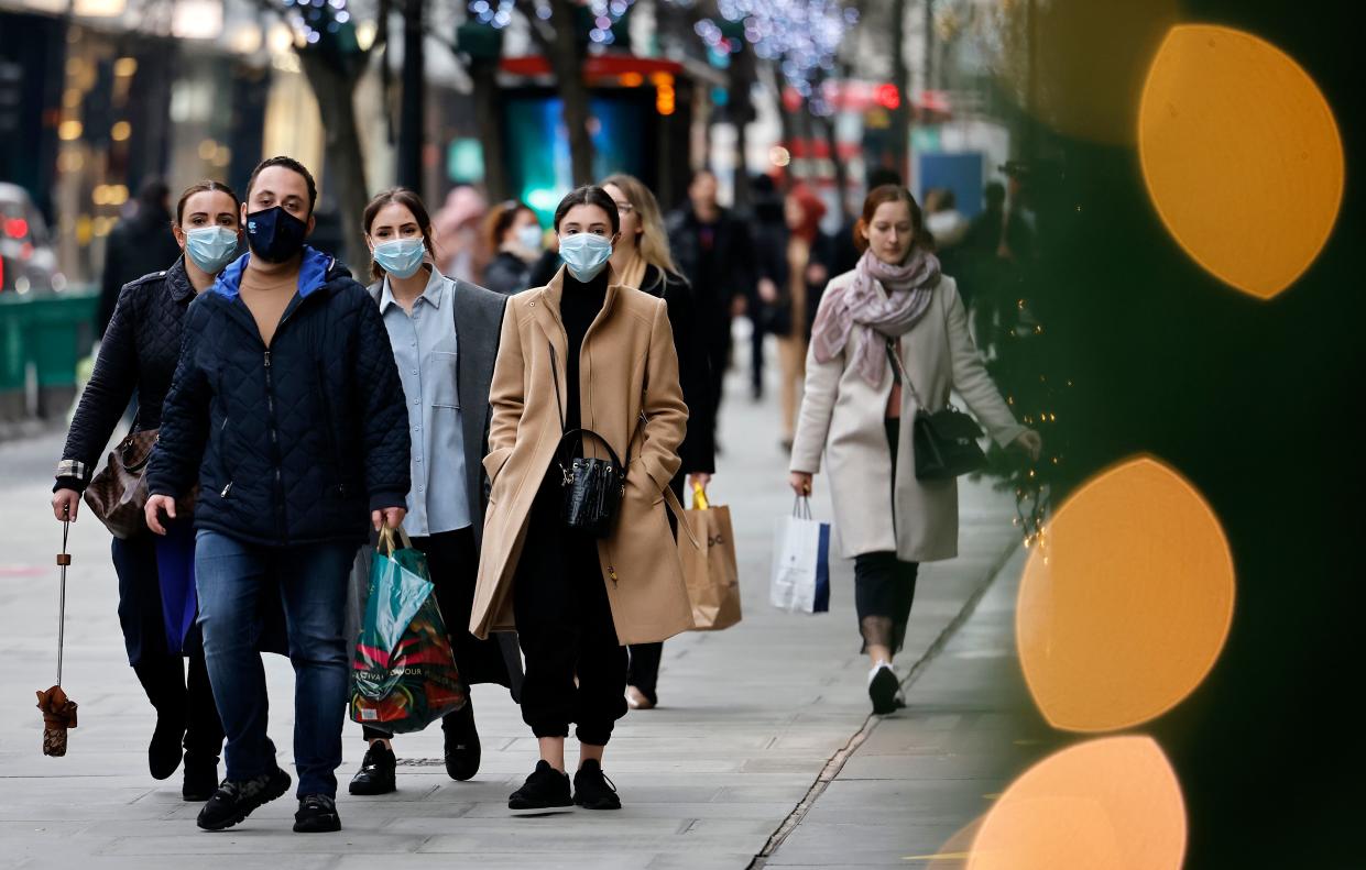 Pedestrians wearing a face mask or covering due to the COVID-19 pandemic, walk along Oxford Street in central London on December 22, 2020. - UK government borrowing continued to soar in November on emergency action to support the virus-hit economy which nevertheless rebounded stronger than expected in the third quarter, official data showed Tuesday. Government borrowing last month hit £31.6 billion ($41.8 billion, 34.2 billion euros), a record for November -- taking public sector net debt to £2.1 trillion, the Office for National Statistics said in a statement. (Photo by Tolga Akmen / AFP) (Photo by TOLGA AKMEN/AFP via Getty Images)