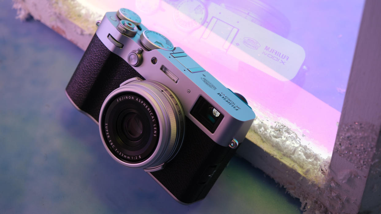  Fujifilm X100VI camera in front of a purple neon light. 