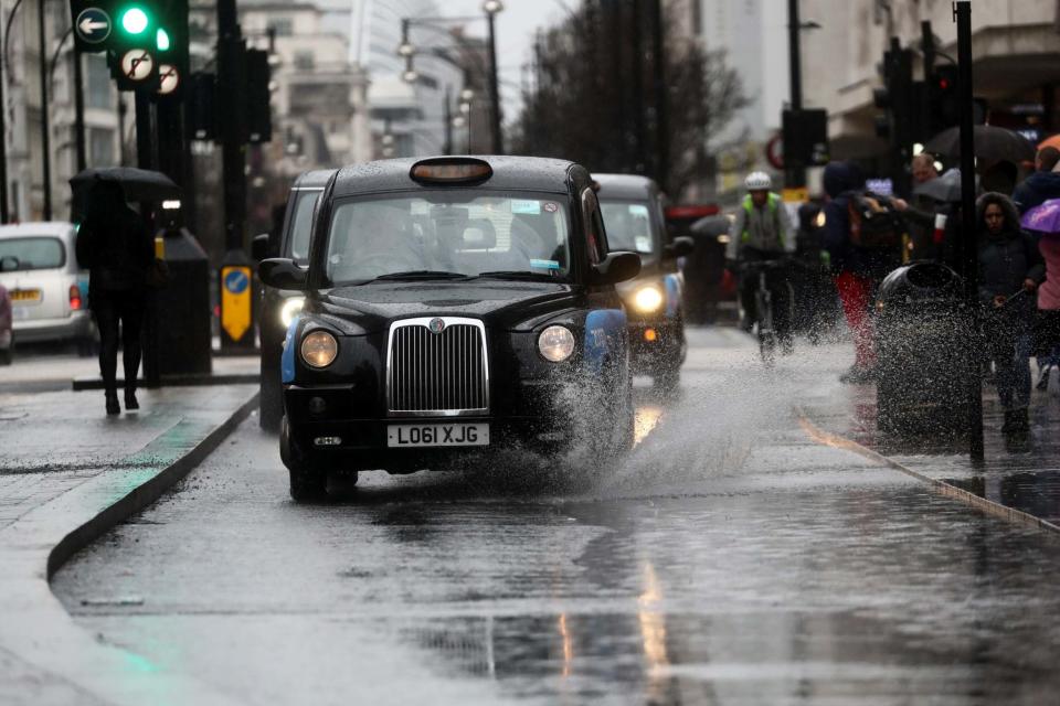 A taxi drives through a puddle on Oxford Street (REUTERS)