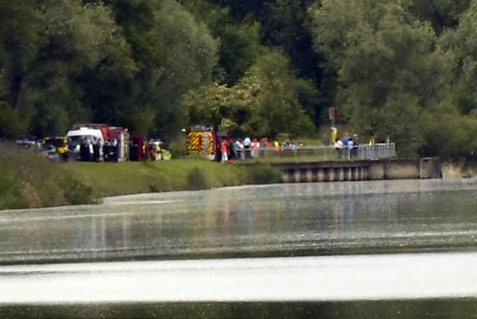 Rescue vehicles and police officers gather near Gerstheim, eastern France, Thursday, May 30, 2019. Police say three people were killed and a child disappeared after a small boat capsized in the Rhine River between Germany and France. (AP Photo)