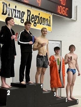 Bloomington North's Max Miller (middle) smiles with his third place ribbon at the Jasper Diving Regional on Tuesday, Feb. 21, 2023.