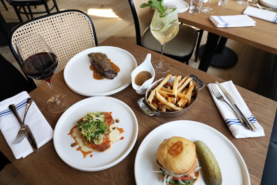 Steak au poivre with green peppercorn sauce, hand cut fries, Micheline burger with homemade bun and crispy chicken leg confit at Micheline, a new French bistro in Scarsdale Sept. 7, 2023.