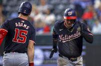 Washington Nationals' Ildemaro Vargas, right, runs to the dugout past Riley Adams (15) after Vargas scored on a single by Alex Call during the second inning of a baseball game against the Texas Rangers in Arlington, Texas, Wednesday, May 1, 2024. (AP Photo/Gareth Patterson)