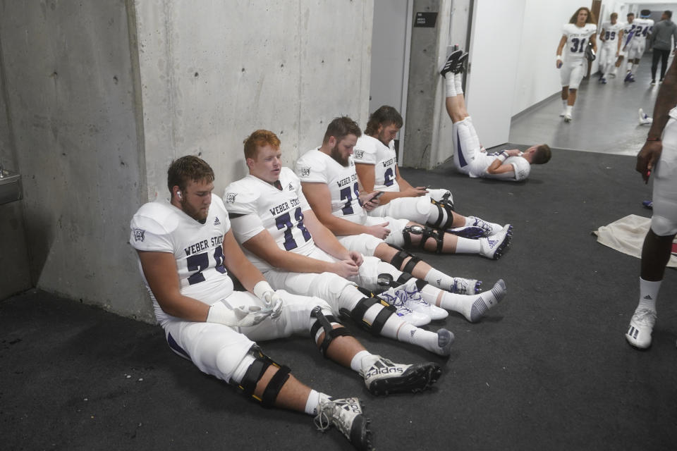 Weber State players wait in the tunnel at Rice-Eccles Stadium during a delay due to inclement weather during the first half of the team's NCAA college football game against Utah on Thursday, Sept. 2, 2021, in Salt Lake City. (AP Photo/Rick Bowmer)