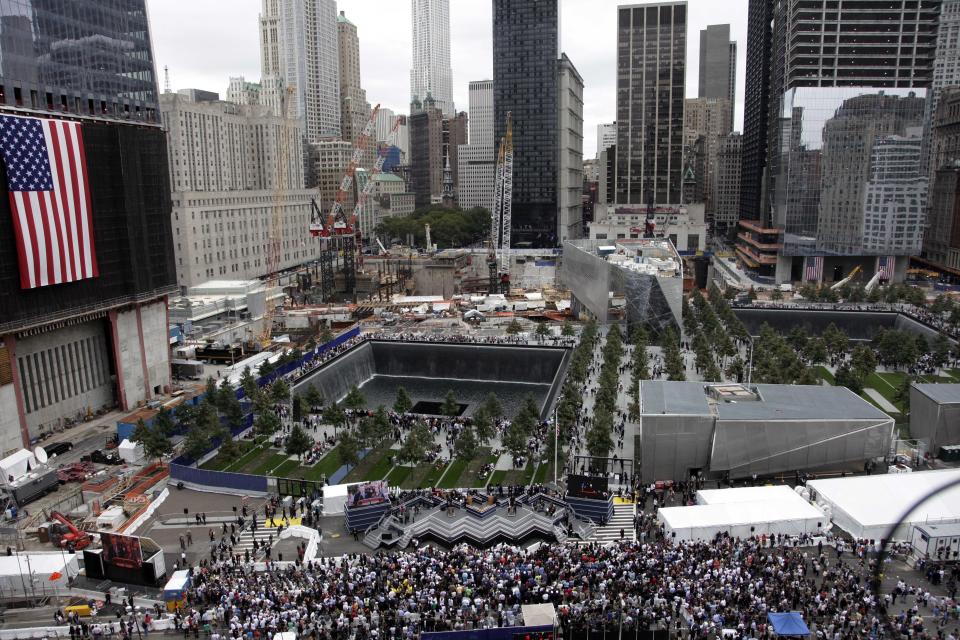 Friends and family members of 9/11 victims visit a September 11 Memorial waterfall during a ceremony marking the 10th anniversary of the attacks, Sunday, Sept. 11, 2011 in New York. (AP Photo/Mark Lennihan)