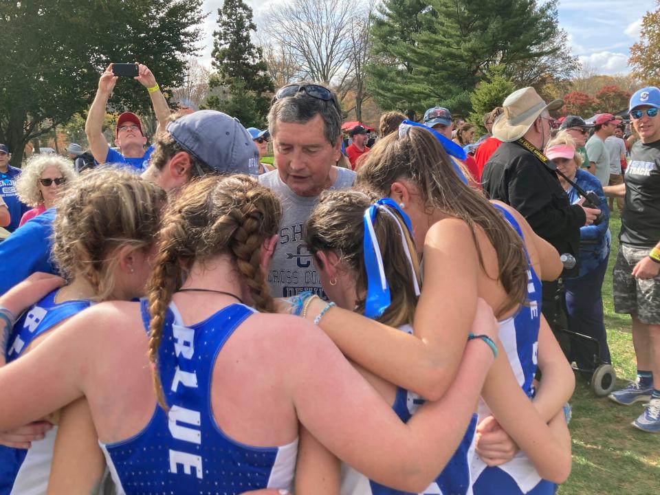 Longtime coach Mel Ullmeyer (center, gray shirt) aLddresses the Shore Regional girls cross country team after they won the Group 1 title