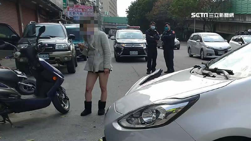 女乘客下車查看傷勢，後方員警正評估肇事原因。