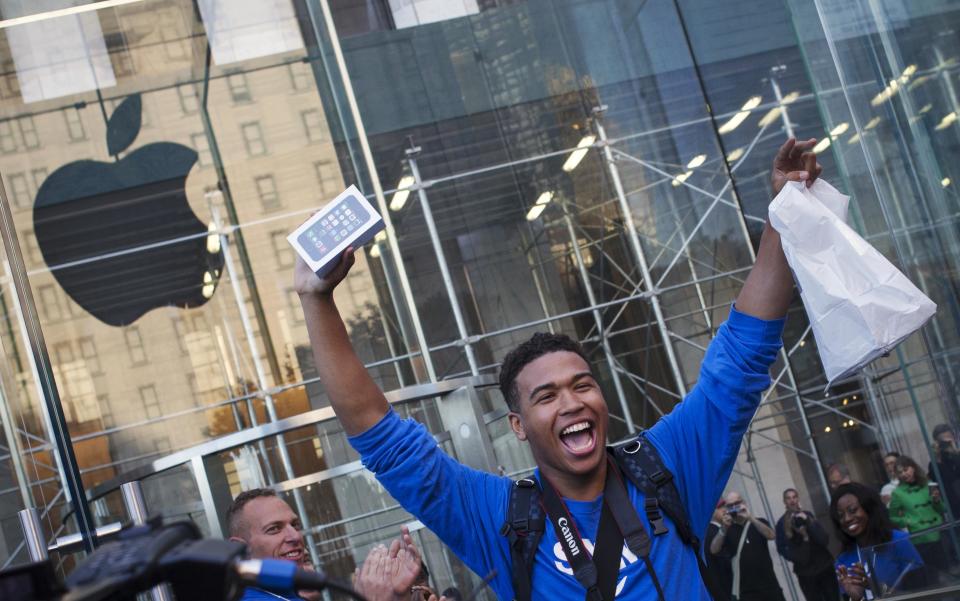 One of the first customers to purchase the Apple iPhone 5S celebrates after exiting the Apple Retail Store on Fifth Avenue in Manhattan, New York September 20, 2013. Apple Inc's newest smartphone models hit stores on Friday in many countries across the world, REUTERS/Adrees Latif (UNITED STATES - Tags: BUSINESS TELECOMS TPX IMAGES OF THE DAY)