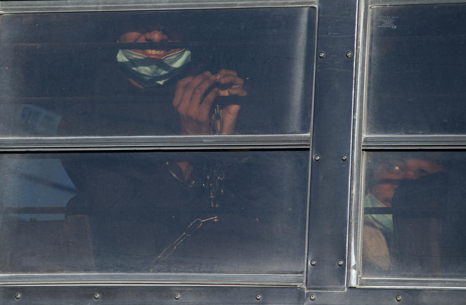 A shackled migrant smiles while transported by bus to board a U.S. Immigration and Customs Enforcement repatriation flight to Guatemala in El Paso, Texas, Wednesday, May 10, 2023. President Joe Biden’s administration on Thursday will begin denying asylum to migrants who show up at the U.S.-Mexico border without first applying online or seeking protection in a country they passed through, according to a new rule released Wednesday, as U.S. officials warned of difficult days ahead as a key limit on immigration is set to expire. (AP Photo/Andres Leighton)