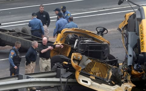 Emergency personnel examine the school bus after the collision - Credit: Seth Wenig/AP