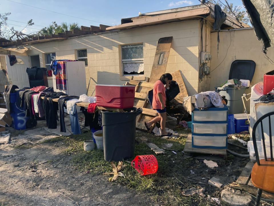 Gloria Galindo walks outside her apartment in Harlem Heights, Fla., Saturday, Oct. 1, 2022, as she helps her mother clean out the building damaged by flooding from Hurricane Ian.(Rebecca Santana)