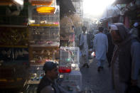 File - In this Tuesday, Oct. 12, 2021 file photo, Afghans walk through a market in Kabul, Afghanistan. With Afghan assets frozen in the U.S. and the world reluctant to recognize the Taliban, the country's banking system has come to a halt. Unpaid salaries and a brewing humanitarian crisis also put more pressure on the new Taliban government, with no clear way out. (AP Photo/Ahmad Halabisaz, File)