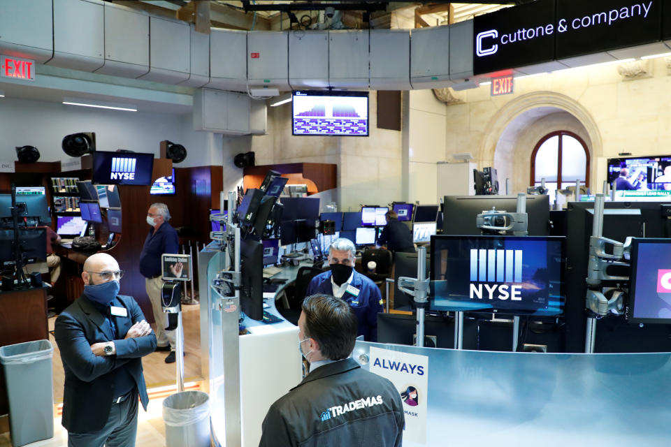 Traders wearing masks work, on the first day of in person trading since the closure during the outbreak of the coronavirus disease (COVID-19) on the floor at the New York Stock Exchange (NYSE) in New York, U.S., May 26, 2020. REUTERS/Brendan McDermid