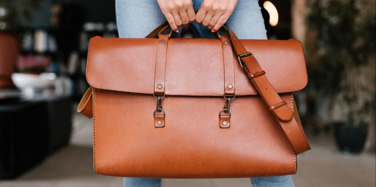 woman holding leather weekender bag