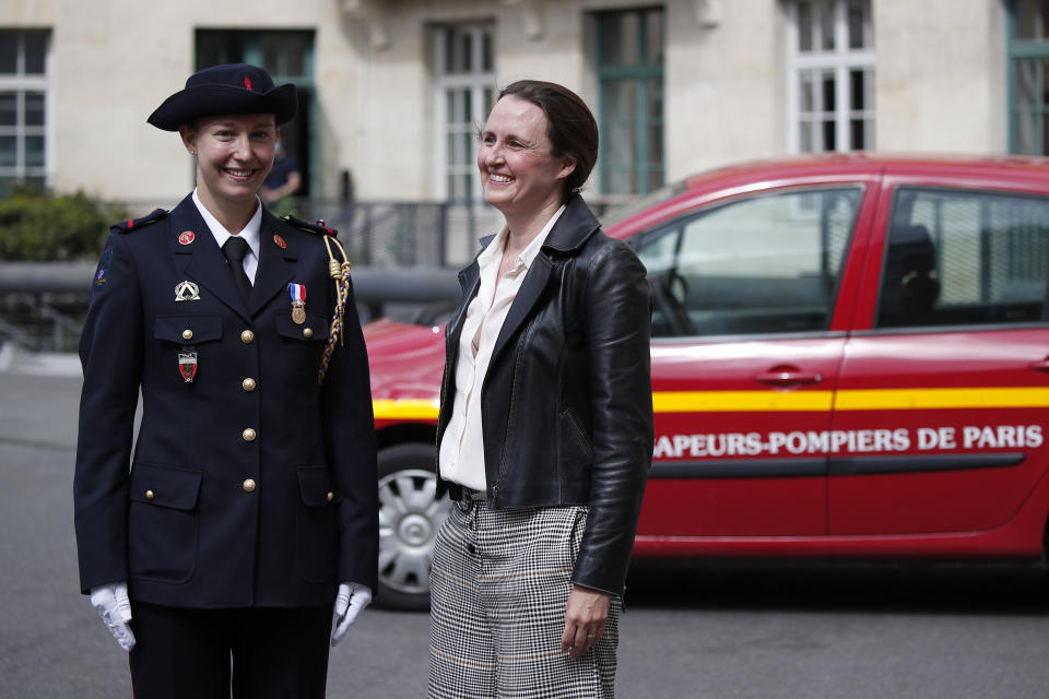 FILE - French math teacher-volunteer fighter, Marion Dehecq, left, poses with Paris-based Associated Press journalist Lori Hinnant, at the Paris fire service headquarters in Paris, France, May 10, 2021. Four Associated Press journalists, including Hinnant, were honored Sunday, Feb. 19, with the George Polk Award for War Reporting for their searing coverage of Russia’s invasion of Ukraine, which Ukrainian officials have credited with saving many lives. (AP Photo/Francois Mori, Pool, File)