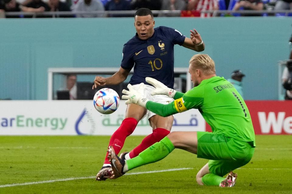 Denmark's goalkeeper Kasper Schmeichel, right, makes a save against France's Kylian Mbappe during the World Cup group D football match between France and Denmark, at the Stadium 974 in Doha, Qatar, Saturday, Nov. 26, 2022. (AP Photo/Thanassis Stavrakis)